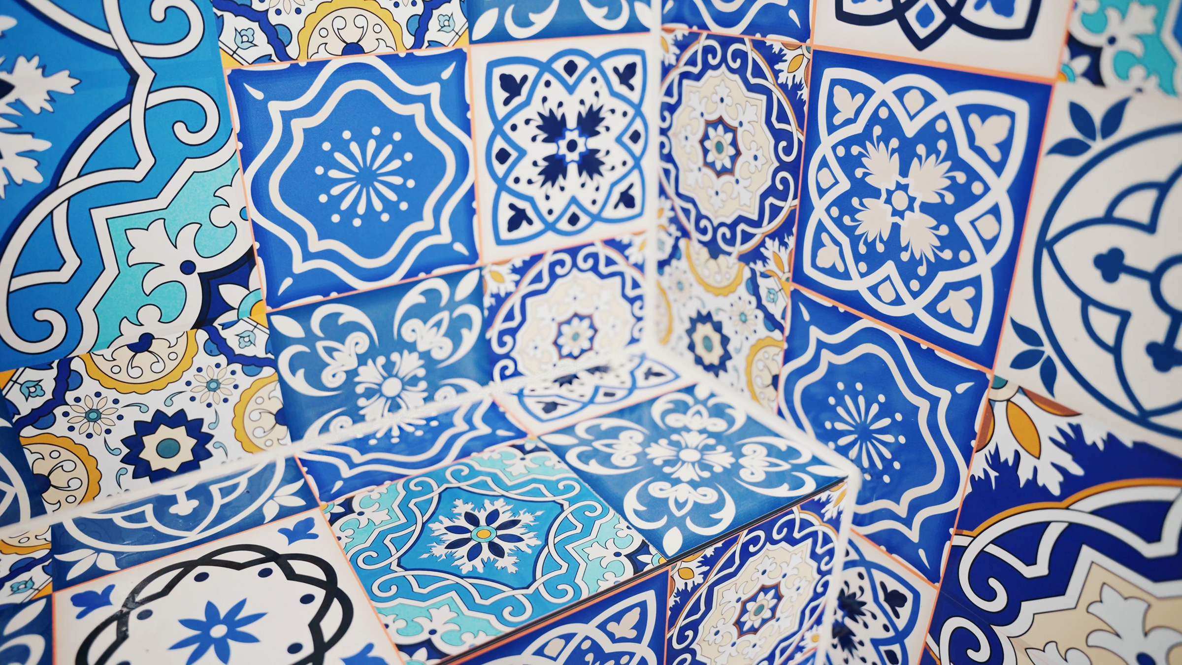Bunte Fliesen mit geometrischen Mustern in Blau- und Weißtönen, verwendet für Fugen.