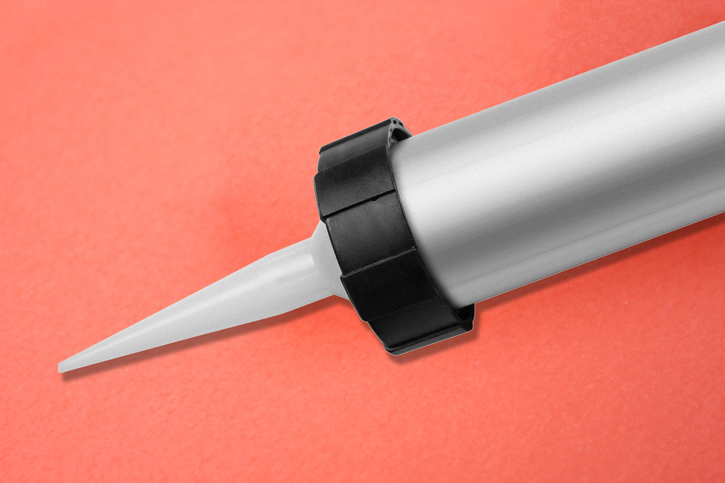 Silikon Pistole mit spitzem Auslauf auf rotem Hintergrund.