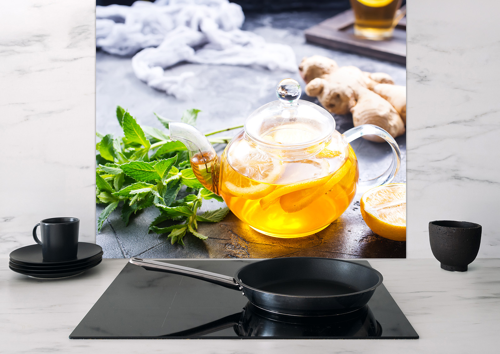 Spritzschutz "Teekanne" mit einem Bild einer Teekanne, die Kräuter und Zitrone enthält, auf einer modernen Küchenoberfläche.