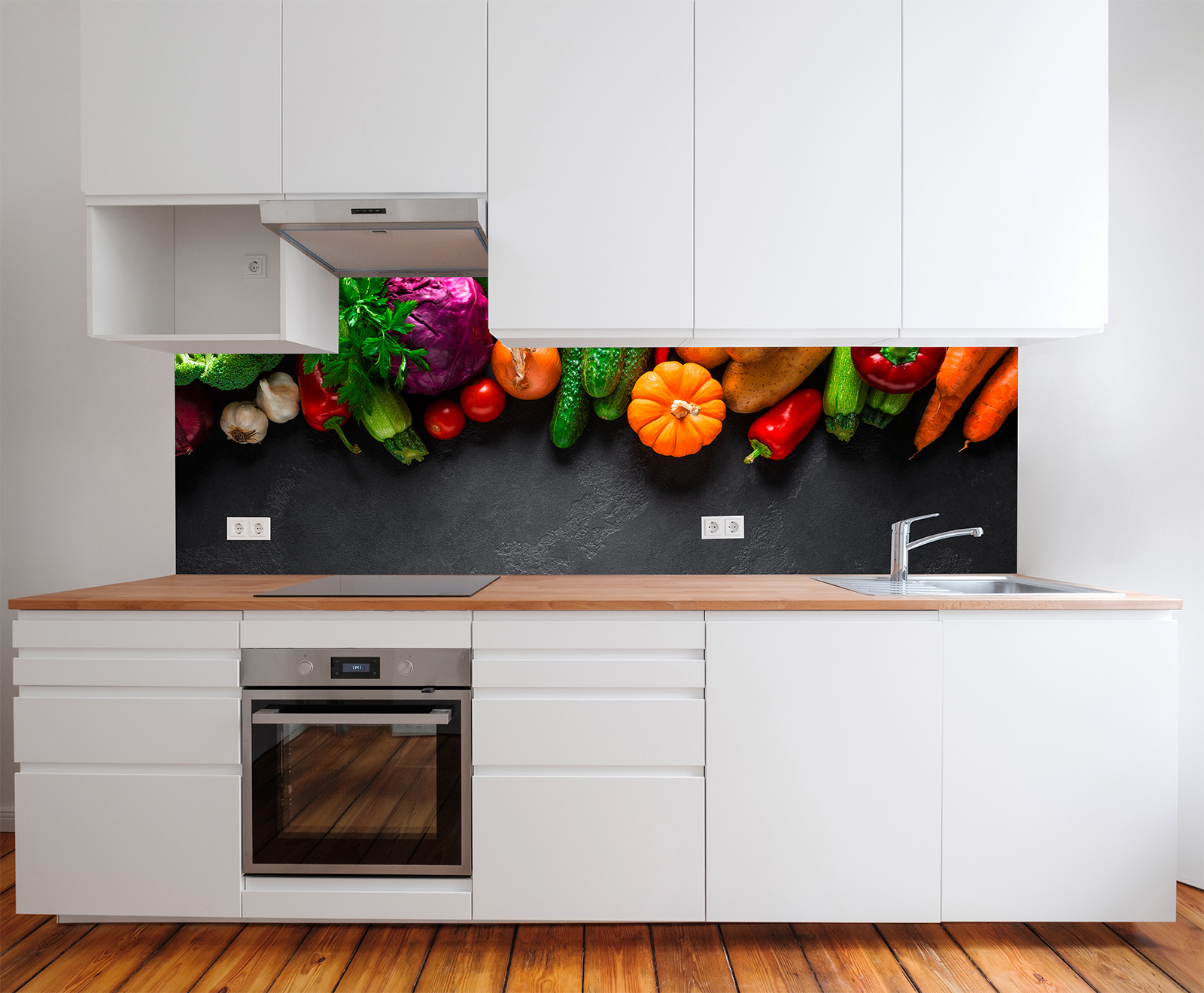 Moderne Küche mit weißen Schränken und Holzarbeitsplatte, im Hintergrund bunte Gemüsearrangements.