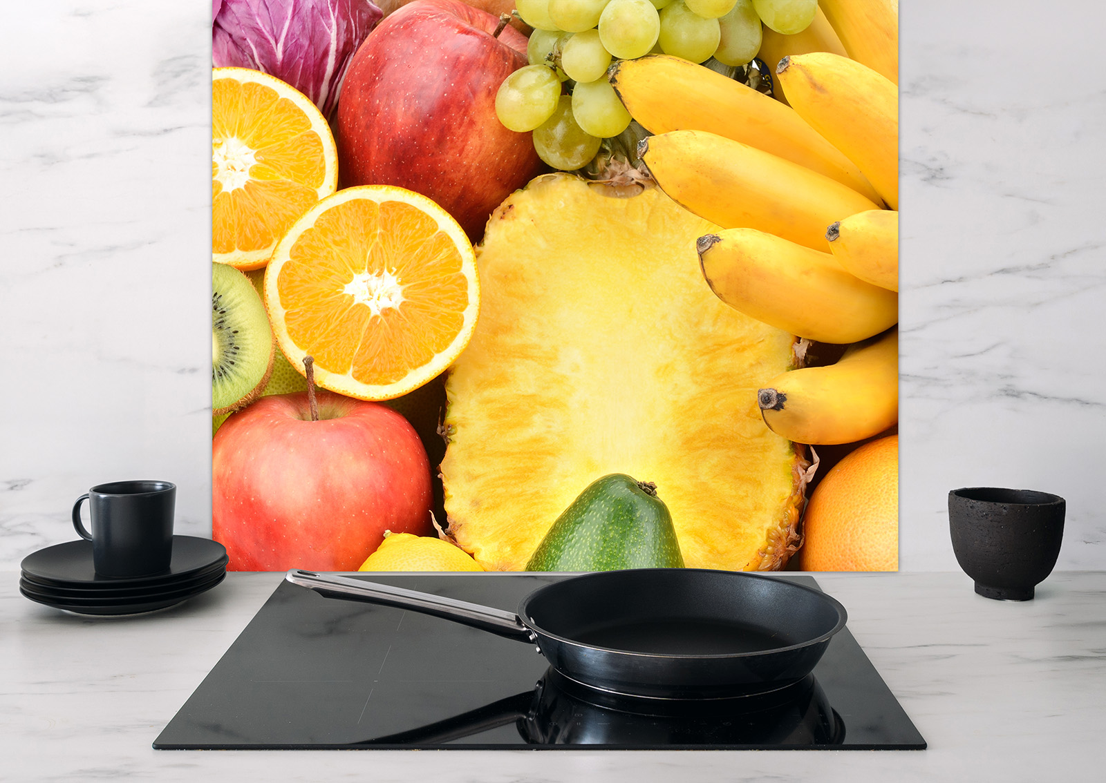 Spritzschutz Obst von ENTDECKER mit bunten Früchten wie Äpfeln, Trauben, Bananen und Ananas im Hintergrund, auf einer modernen Küchenoberfläche.