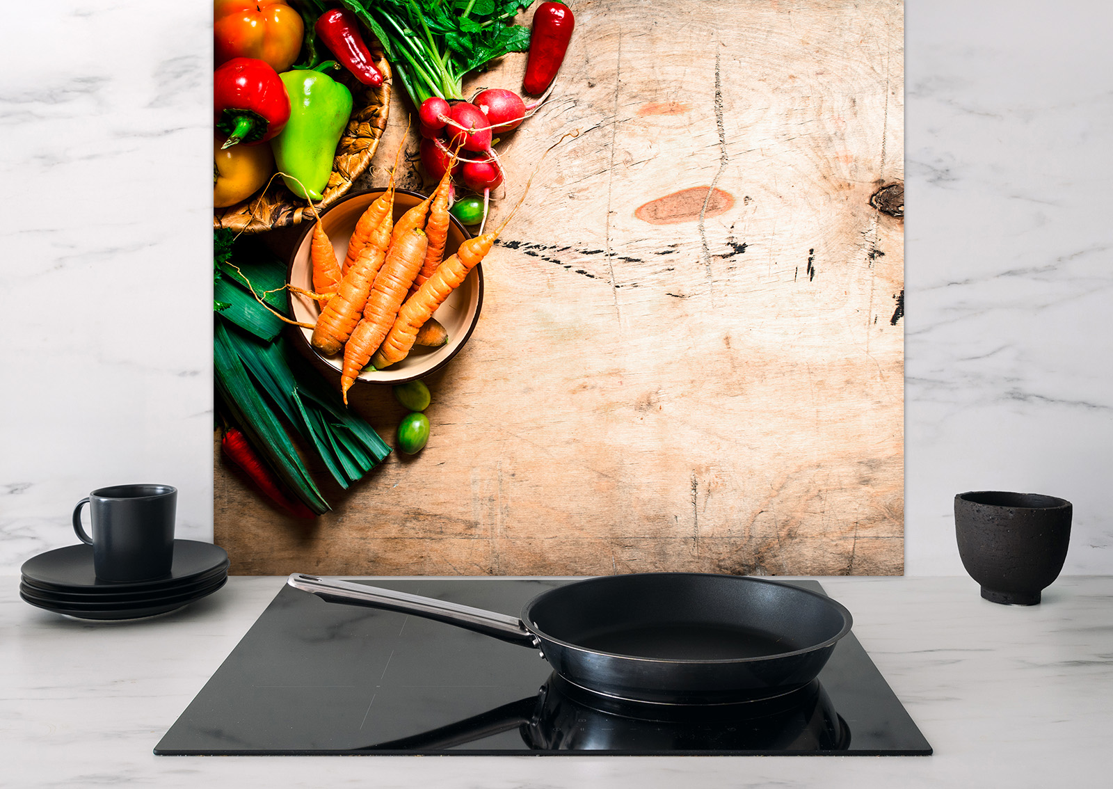 Spritzschutz Gemüsekörbe von ENTDECKER mit buntem Gemüse auf einer Holzoberfläche, darunter eine Pfanne und Geschirr.