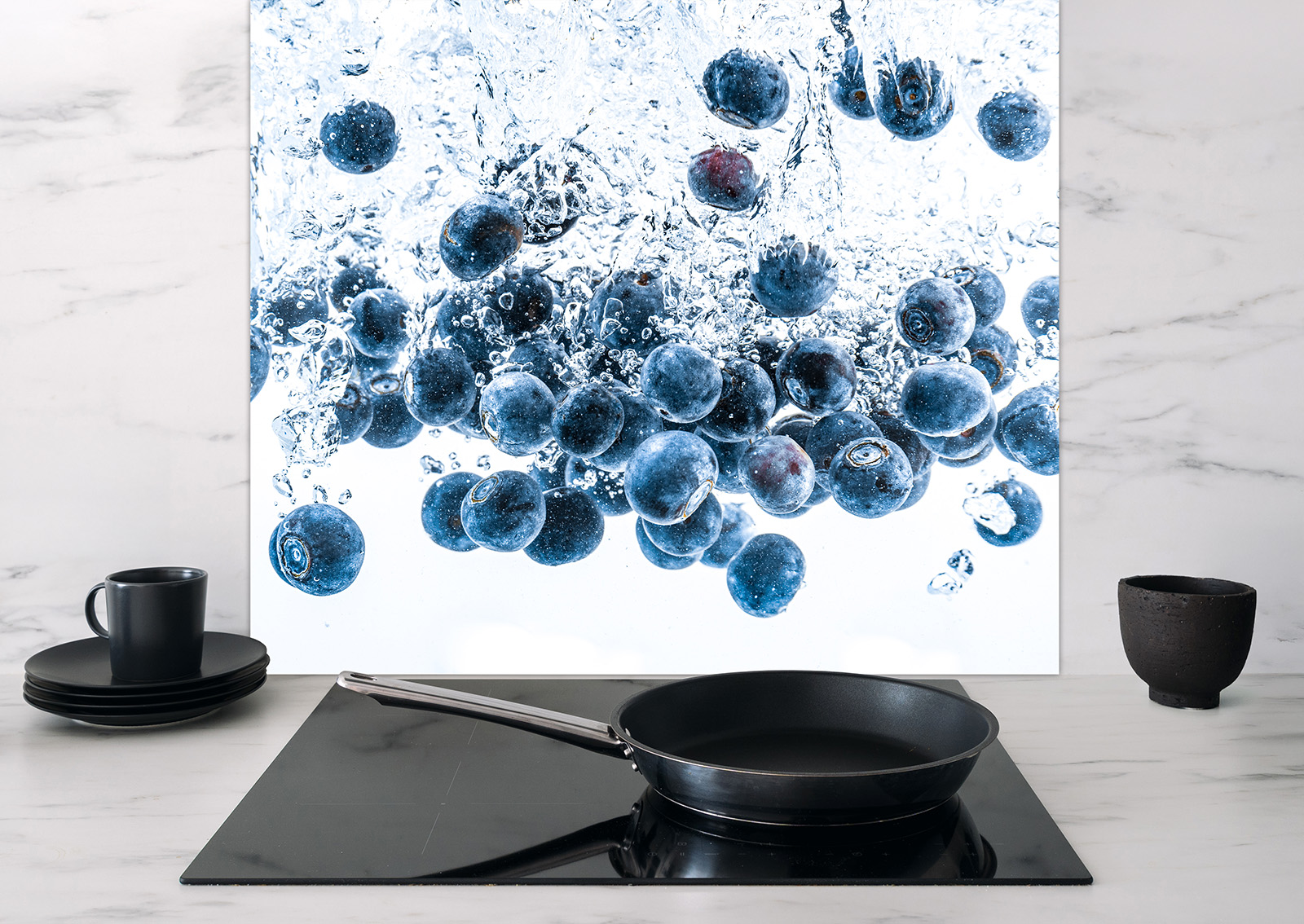 Spritzschutz Blaubeeren von ENTDECKER mit spritzenden Blaubeeren in Wasser, auf einer modernen Kochplatte.