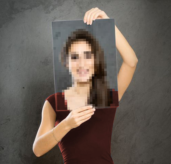 Eine Person hält ein verschwommenes Bild einer Frau vor einem grauen Hintergrund.