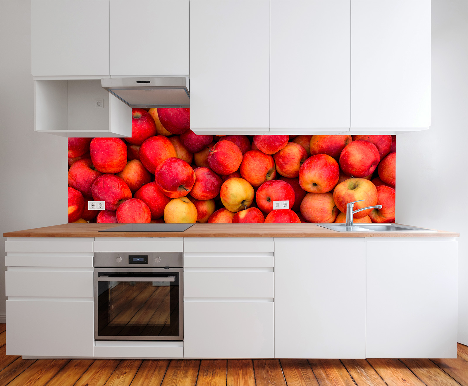 Moderne Küche mit weißen Schränken und Holzarbeitsplatte, im Hintergrund eine Wand mit roten und gelben Äpfeln.
